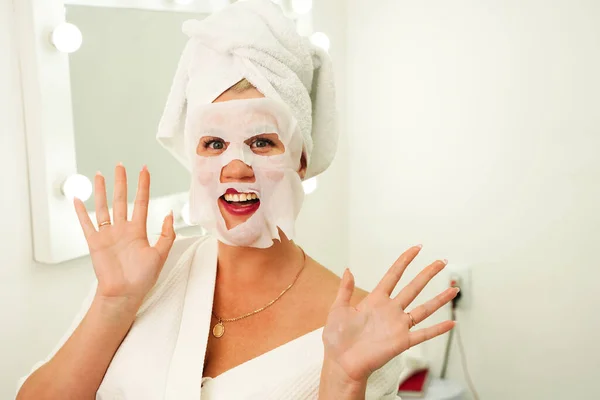 Beauty Skin Care Concept - Bella donna caucasica che applica una maschera di carta sul suo viso bianco — Foto Stock