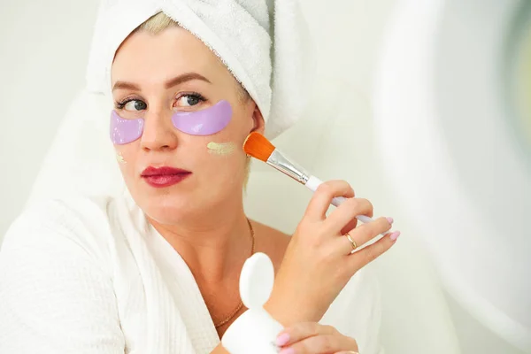 Donna applica il trucco al suo viso, attenzione selettiva sulla pelle e pennello. Applicando fondazione a pelle pigmentata con una spazzola. Sovrapposizione delle imperfezioni cutanee con i cosmetici. — Foto Stock