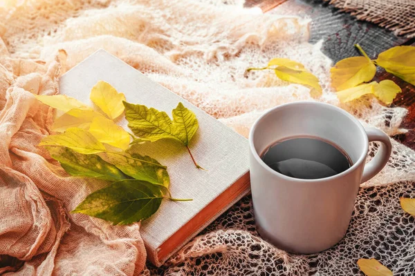 Outono, folhas de outono, quente vapor xícara de café e um lenço quente no fundo da mesa de madeira. Sazonal, café da manhã, domingo relaxante e ainda conceito de vida. — Fotografia de Stock
