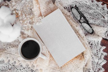 Kitap, görüş için bardak ve tekstil arka planında çay.