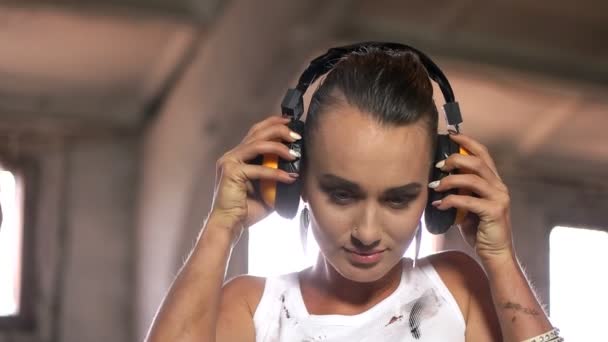 Mujer joven se pone auriculares de construcción — Vídeo de stock