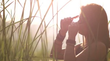 Siyah elbiseli bir genç kadın güneş gözlüğü backlight üstünde koyar