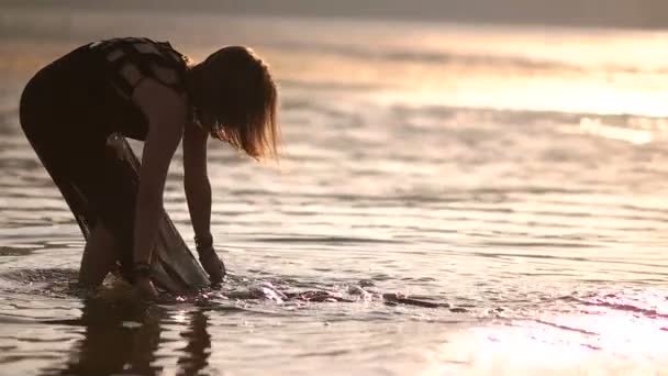 Dívka vypere oblečení transparentní černé pareo v řece — Stock video