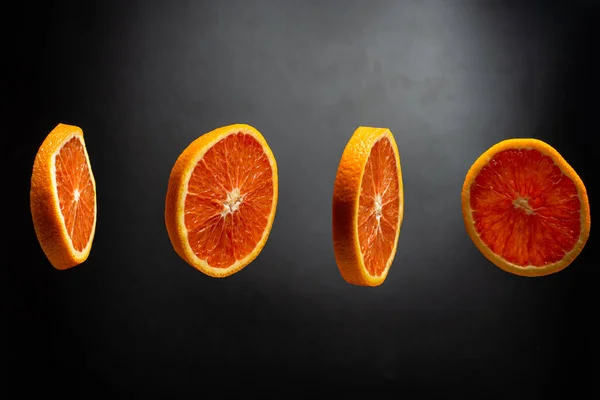 Cuatro Rebanadas Redondas Naranja Fresca Flotando Aire Sobre Fondo Negro — Foto de Stock