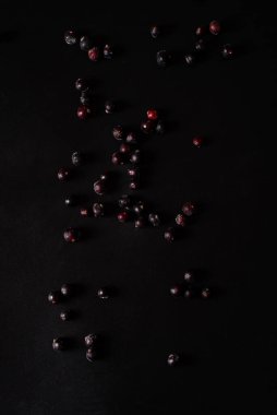 Siyah arkaplana saçılmış donmuş kuşüzümü.