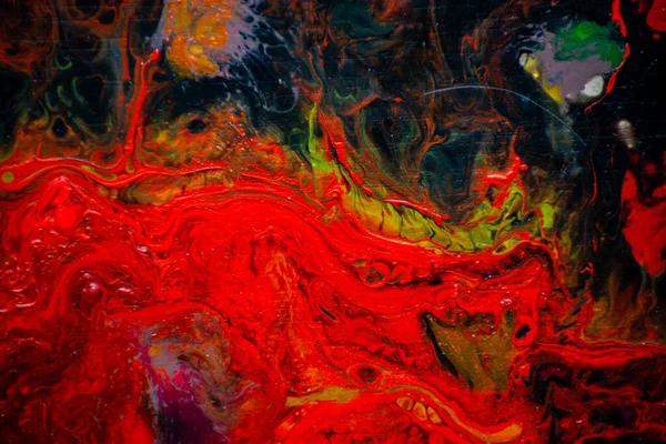 Texture in the style of fluid art. Abstract background with swirling paint effect. Liquid acrylic paint background. Red, black and yellow colors.