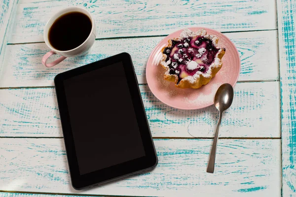 Ein Digitales Tablet Eine Tasse Kaffee Und Ein Kuchenkorb Mit lizenzfreie Stockbilder