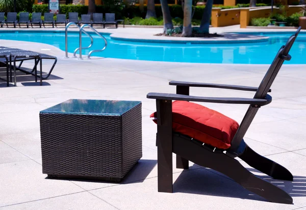 Chaise de plage et table au bord d'une piscine — Photo