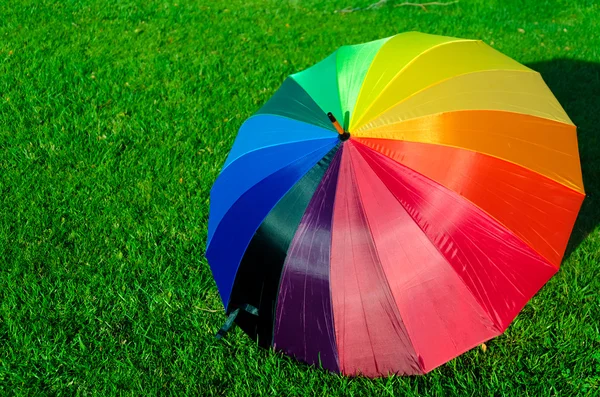 Rainbow umbrella on the grass — Stock Photo, Image