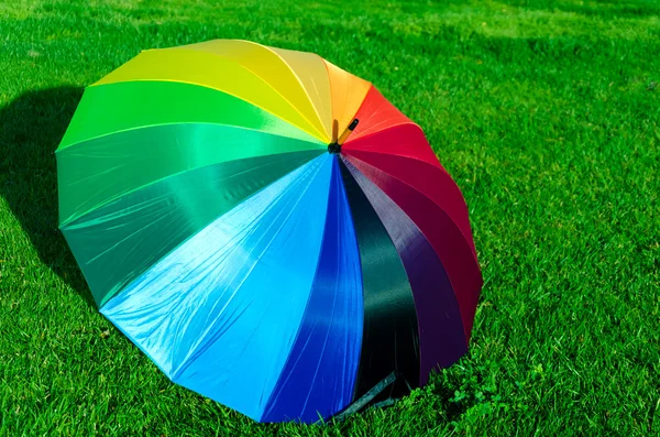 Guarda-chuva arco-íris na grama — Fotografia de Stock