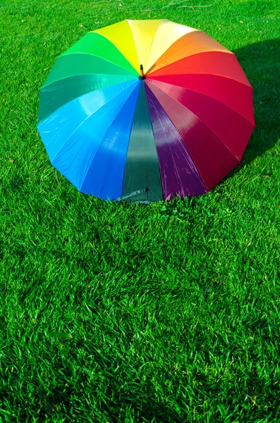 Rainbow umbrella on the grass — Stock Photo, Image