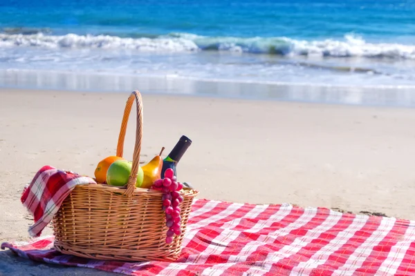 Cesta de piquenique com frutas junto ao oceano — Fotografia de Stock