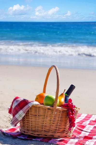 Корзина для пикника с фруктами у океана — стоковое фото