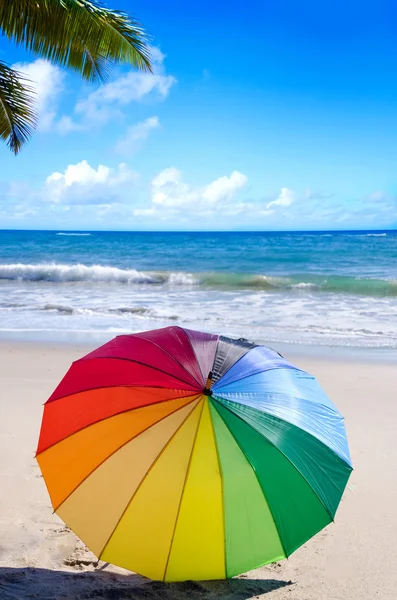 Rainbow umbrella by the ocean — Stock Photo, Image