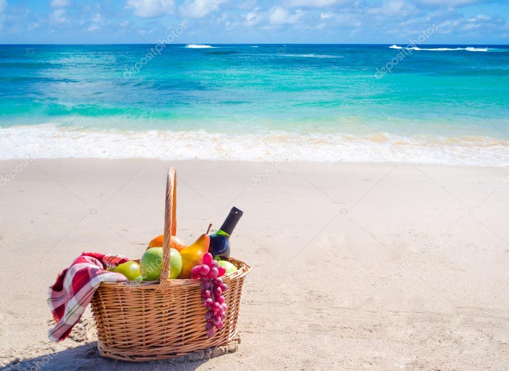 Picnic basket with fruits by the ocean