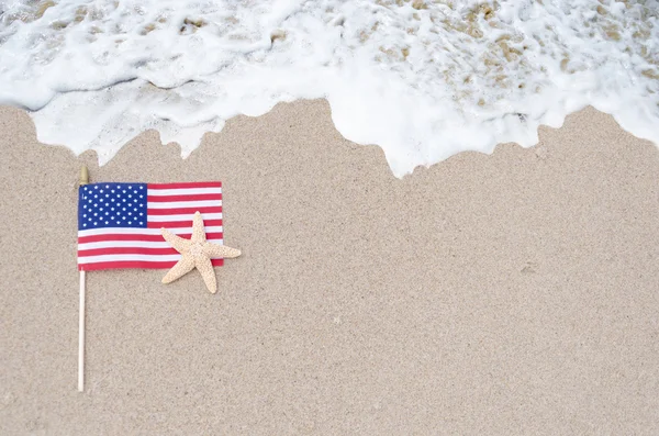 Bendera Amerika dengan bintang laut di pantai berpasir — Stok Foto