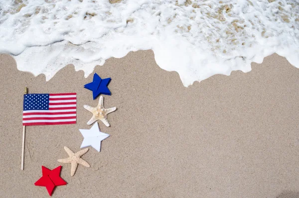 Bandiera americana con stelle marine sulla spiaggia di sabbia — Foto Stock