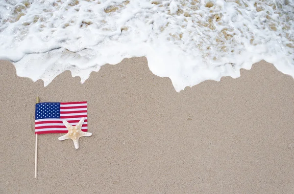 American flag with starfish on the sandy beach