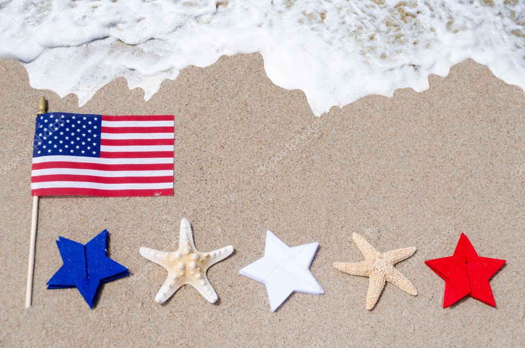 American flag with starfishes on the sandy beach