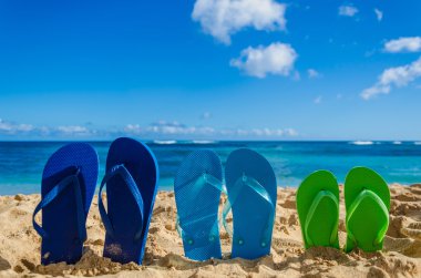 Colorat flip flopi pe plaja de nisip