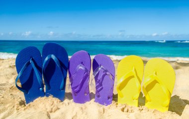 Colorat flip flopi pe plaja de nisip
