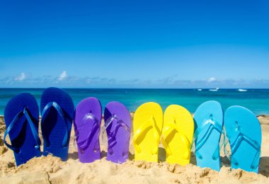 Colorat flip flopi pe plaja de nisip