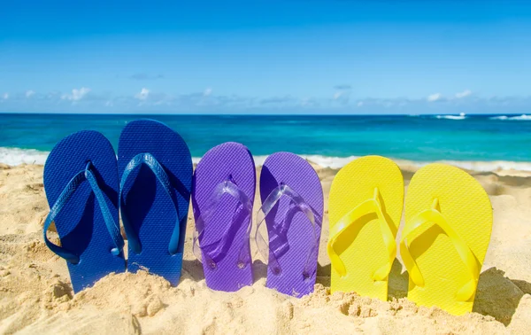 Chinelos coloridos na praia de areia — Fotografia de Stock