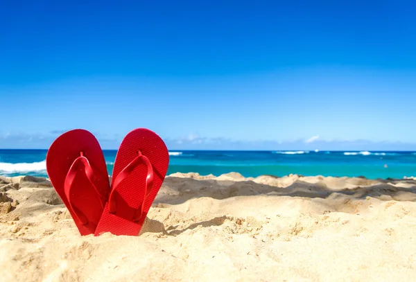 Chanclas rojas en la playa de arena —  Fotos de Stock