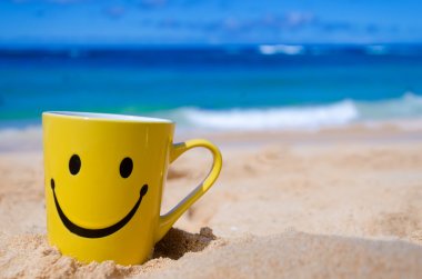 Happy face mug on the beach