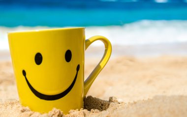 Happy face mug on the beach