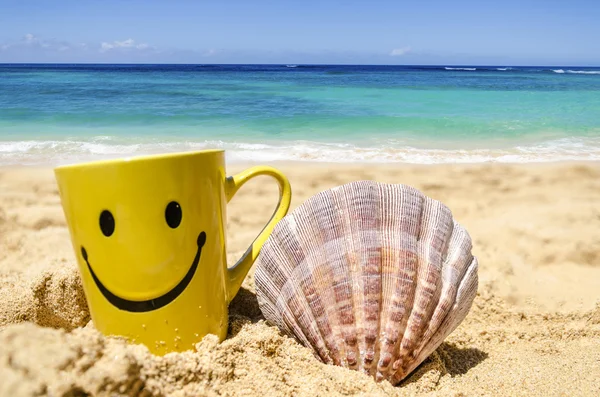 Taza cara feliz en la playa con concha — Foto de Stock