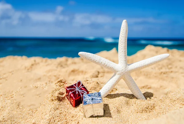 Starfish com caixas de presente na praia de areia — Fotografia de Stock