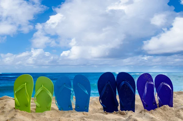 Kleurrijke flip flops op het zandstrand — Stockfoto