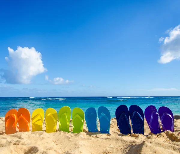Chinelos coloridos na praia de areia — Fotografia de Stock