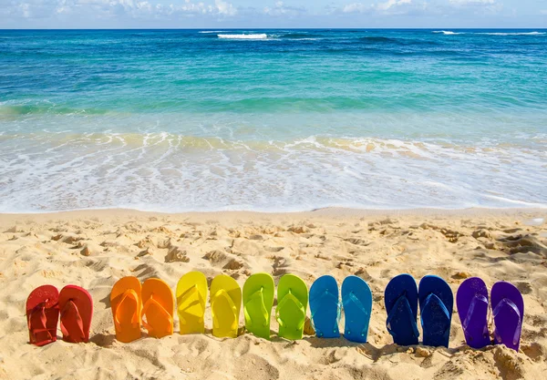 Chanclas de colores en la playa de arena —  Fotos de Stock