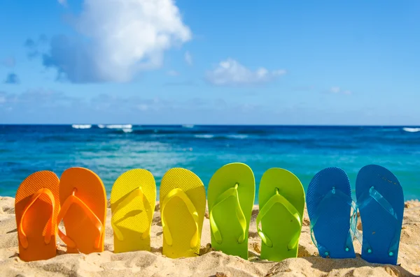 Kleurrijke flip flops op het zandstrand — Stockfoto
