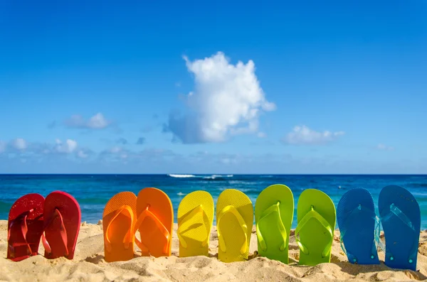 Chinelos coloridos na praia de areia — Fotografia de Stock