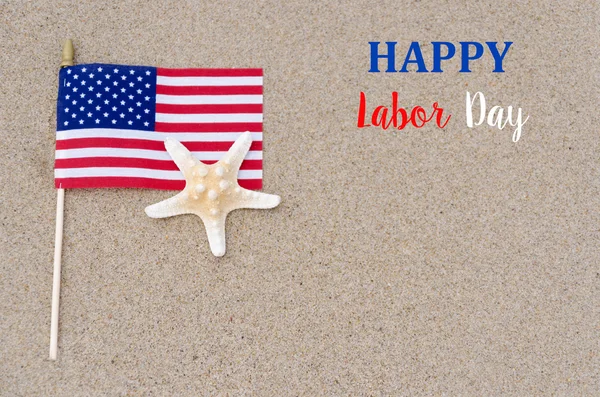 Happy labor day background with flag, starfish on the sandy beac