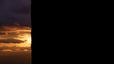 Gün batımında dağın tepesinde güzel gökyüzü manzarası olan ağacın gölgesi..