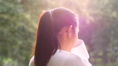 Genç bir kadının dışarıda sıcak kahve içişini ve tatilin tadını çıkarışını sabah güneş ışığıyla dağda..