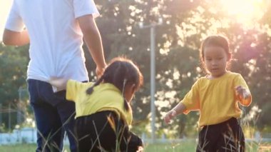 Mutlu anne ve kızları yazın tarlada koşup oynuyorlar. Aile tatilde birlikte zaman geçirdi..