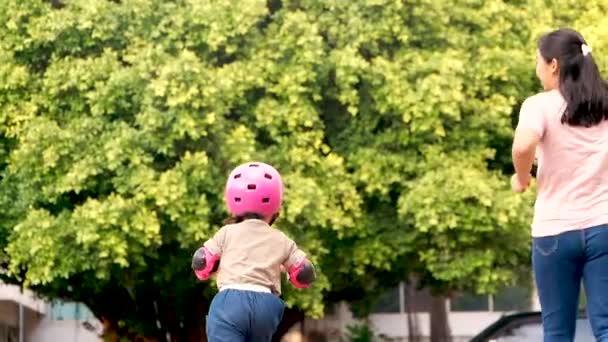 夏の公園でスクーターに乗りながら転んだ後 母は娘を慰め 抱きかかえています 子供のためのアクティブな屋外スポーツ — ストック動画