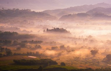 Güneşin doğuşuyla güzel bir manzara Dağların zirvesinde bulutlar.