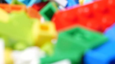 Masanın üzerinde farklı renkte ve şekillerde bir sürü oyuncak bloğu var. Çocuklar için eğitici bir oyuncak. Lego. Seçici odak.