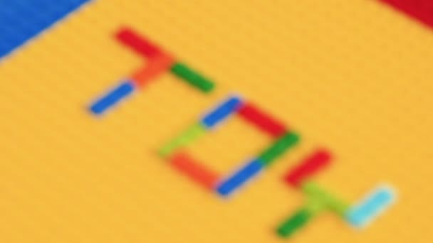 黄色の背景におもちゃのカラフルな文字と色のおもちゃのレンガ 子供のための教育玩具 — ストック動画