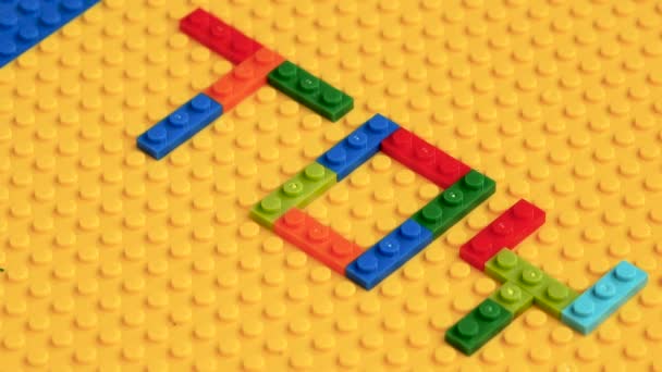 Gekleurde Speelgoed Bakstenen Met Toy Kleurrijke Letters Gele Achtergrond Educatief — Stockvideo