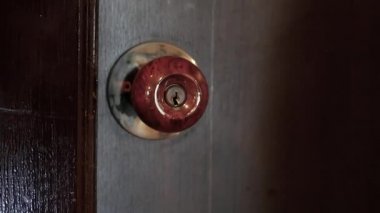 Otel odasının kapısını açmak ve açmak için anahtarı kullanan bir kadının, kapıyı kapalı bir şekilde odaya girerken yakın çekimi..
