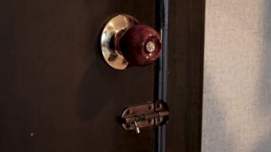 Bir kadının otel odasının kapısını açarken ve kapıyı kapalı bir şekilde odadan çıkarken..