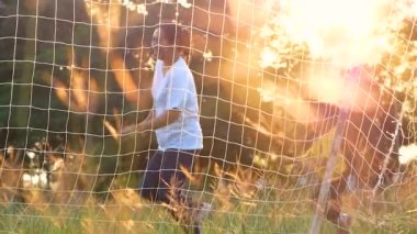 Mutlu anne ve kızları yaz parkında çimlerde gülüp oynuyorlar. Aile tatilde birlikte zaman geçirdi..
