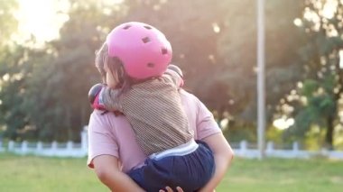 Motosiklet sürmekten yorulduktan sonra annesiyle birlikte yaz parkında sırtına binen sevimli küçük bir kız. Aile tatilde birlikte zaman geçirdi..